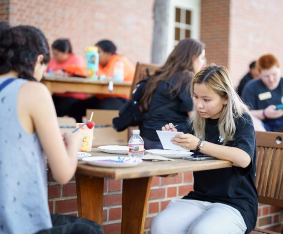 students at tables outside the duc